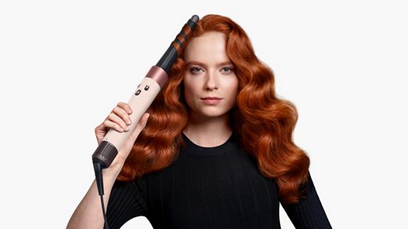  Vue de face d'une femme frisant ses cheveux avec le Dyson Airwrap ID.