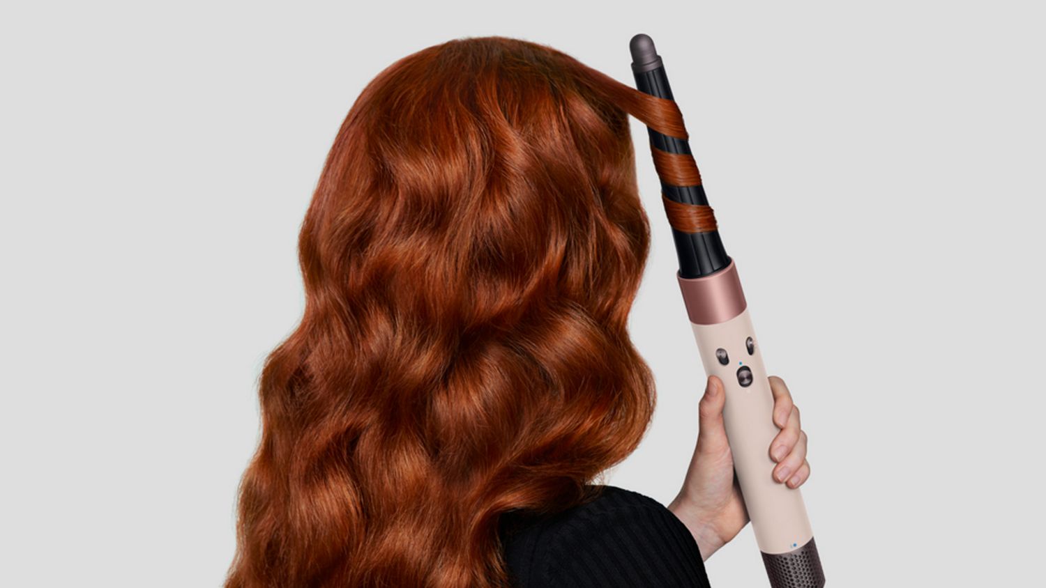Front-on view of a woman curling her hair with the the Dyson Airwrap ID.