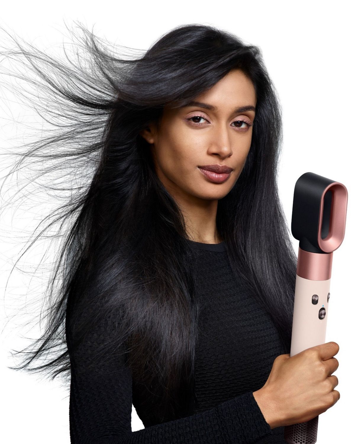 Model holding the Dyson Airwrap ID multi-styler and dryer with the Fast dryer attachment.