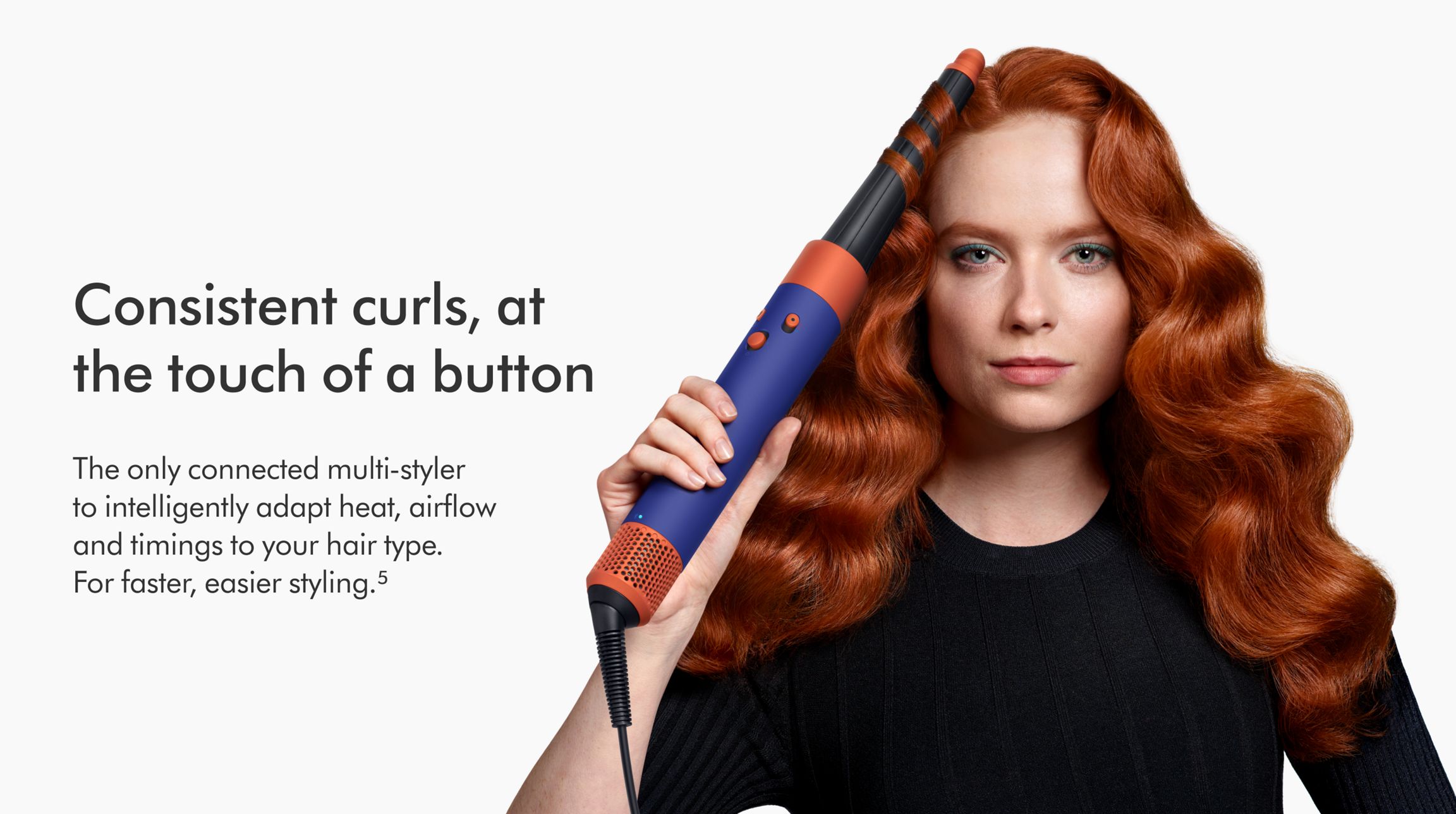 Dyson HS08 Airwrap i.d.™ multi-styler and dryer Straight+Wavy (Vinca Blue/Topaz) 3 Woman curling hair with the Dyson Airwrap ID multi-styler.