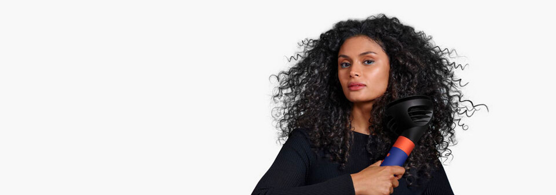 Modelo a usar o Dyson Airwrap i.d. para secar o cabelo.