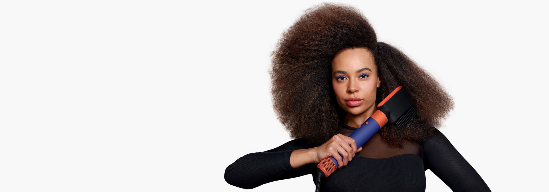  Model using the Dyson Airwrap i.d. to dry hair.