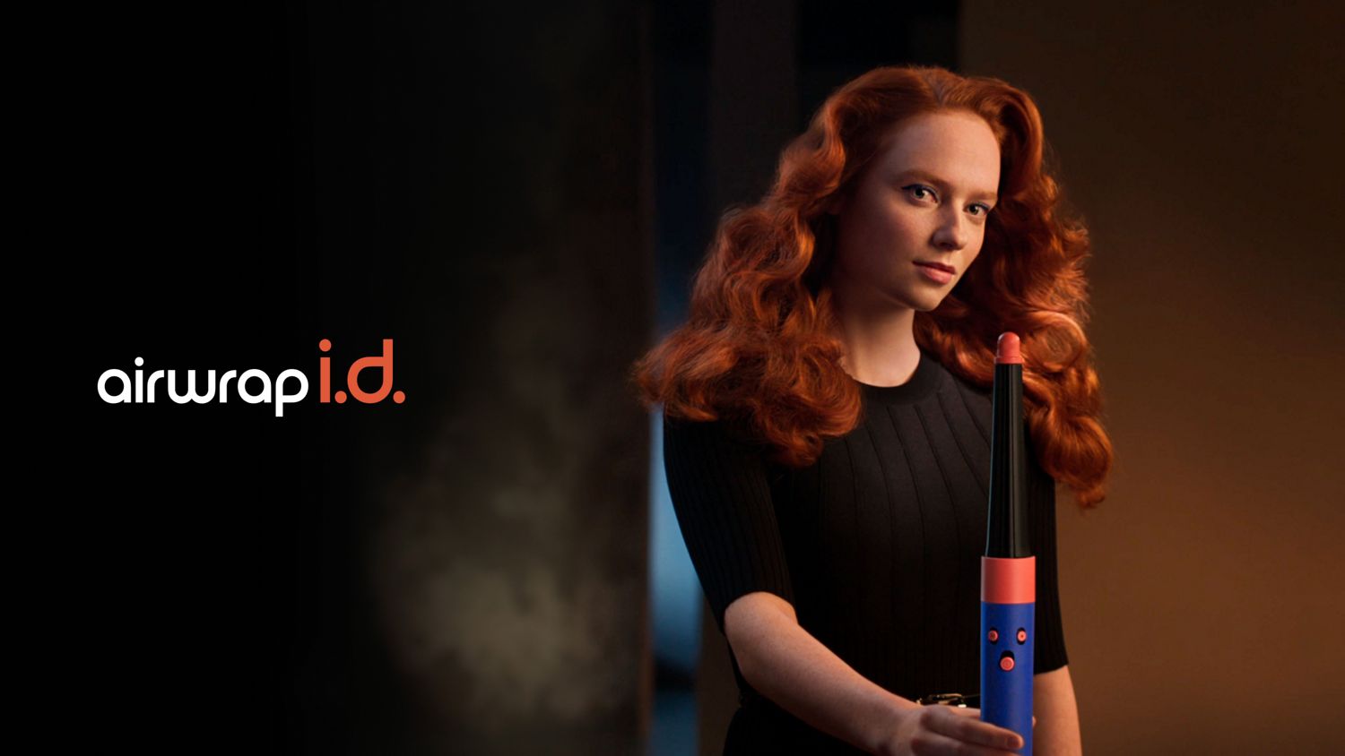 Front-on view of woman with curly, styled hair, holding the Dyson Airwrap ID.