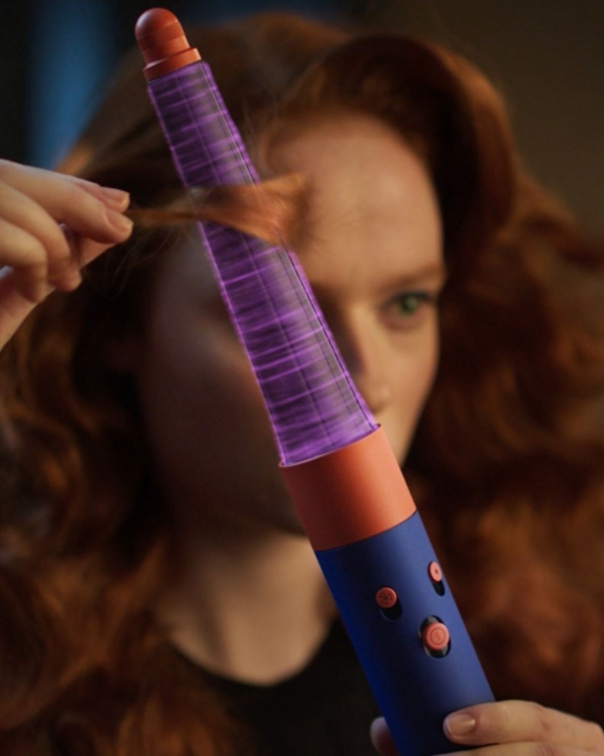 Model using Vinca Blue Dyson Airwrap i.d multi-styler and dryer to add waves to their hair.