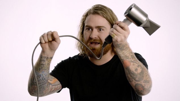 En hårstylist som holder den lange ledningen til Dyson Supersonic™ hårføner Professional Edition