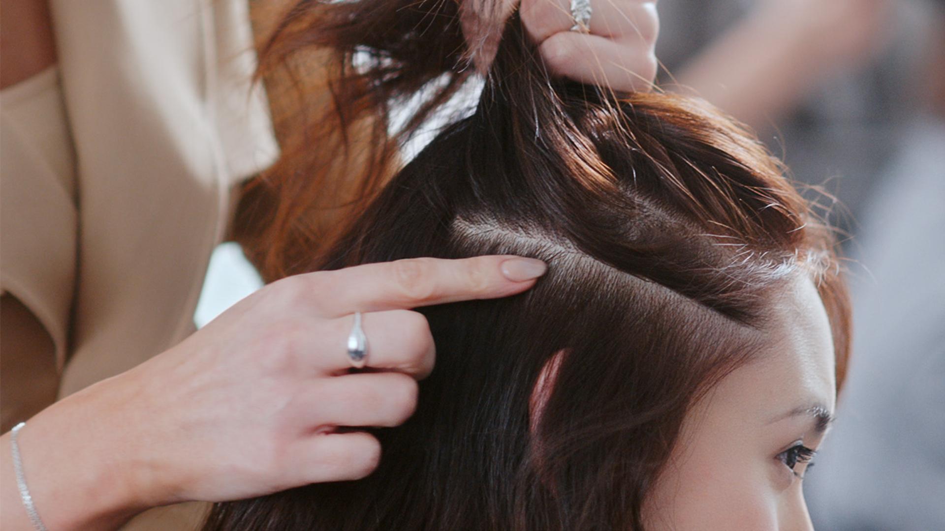 Zbliżenie na skórę głowy pomiędzy pasmami włosów modelki