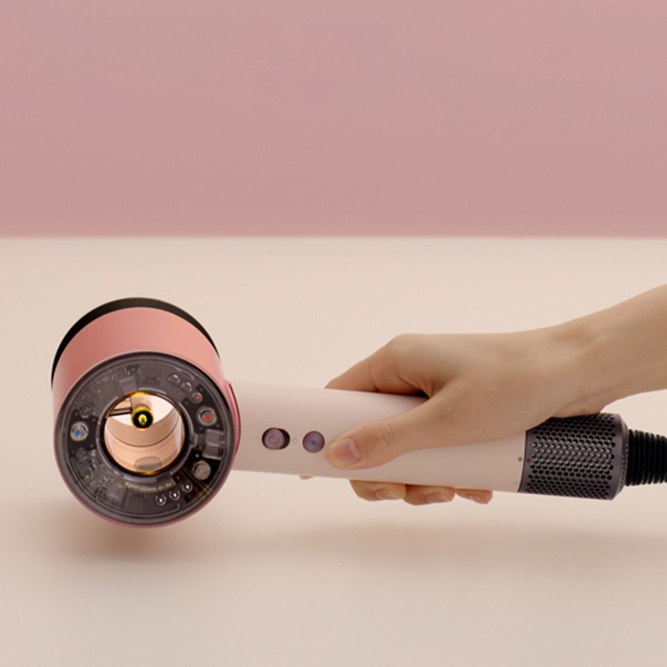 Ein Dyson Supersonic Nural Haartrockner wird auf einen Tisch gelegt. Ein Dyson Supersonic Nural Haartrockner wird auf einen Tisch gelegt.