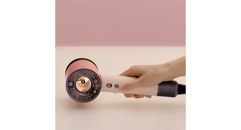 Ein Dyson Supersonic Nural Haartrockner wird auf einen Tisch gelegt.