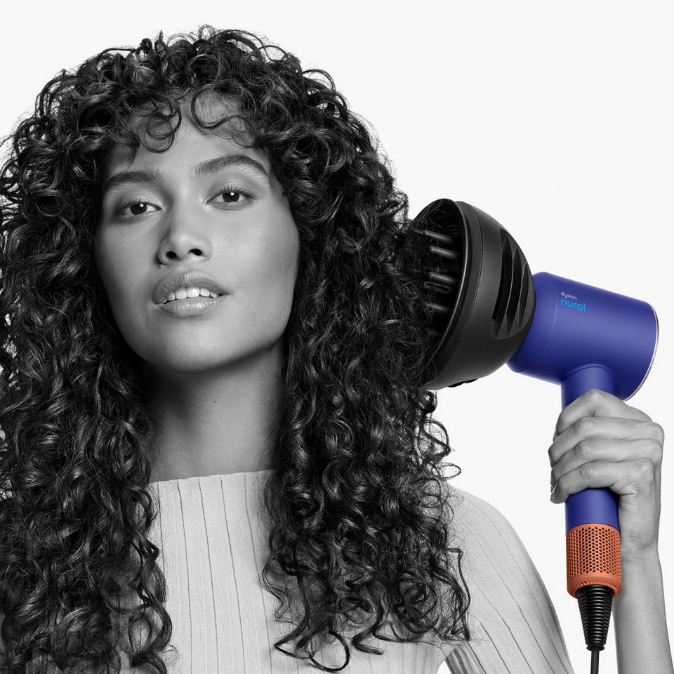 Ein Model verwendet den Dyson Supersonic Nural Haartrockner mit dem Wellen und Locken Diffusor im Diffusor-Modus.