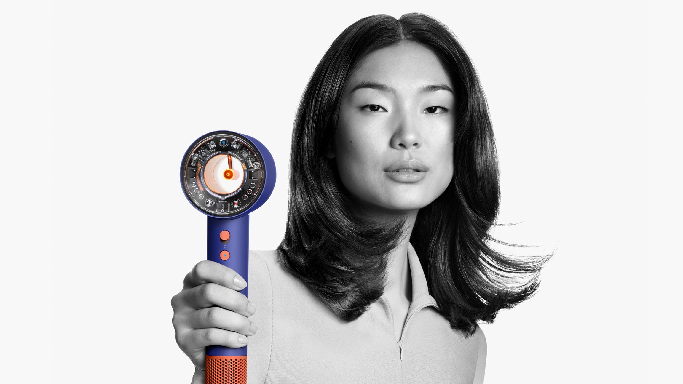 Uma modelo feminina a utilizar o secador de cabelo Dyson Supersonic Nural