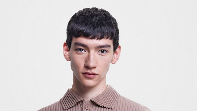 Male model with short, straight hair.