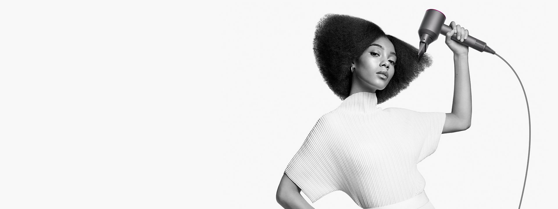 Mulher a modelar o cabelo com o pente acessório Wide-tooth da Dyson 