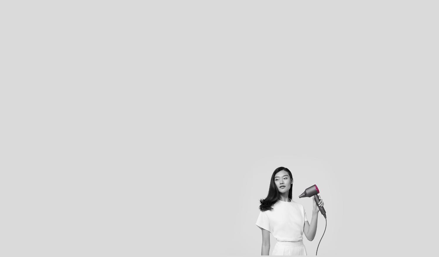 Woman using Dyson Supersonic with Smoothing nozzle