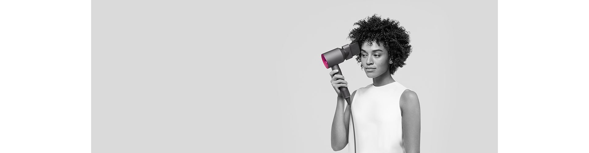   En kvinne bruker Dyson Supersonic med Wide-tooth comb-tilbehøret