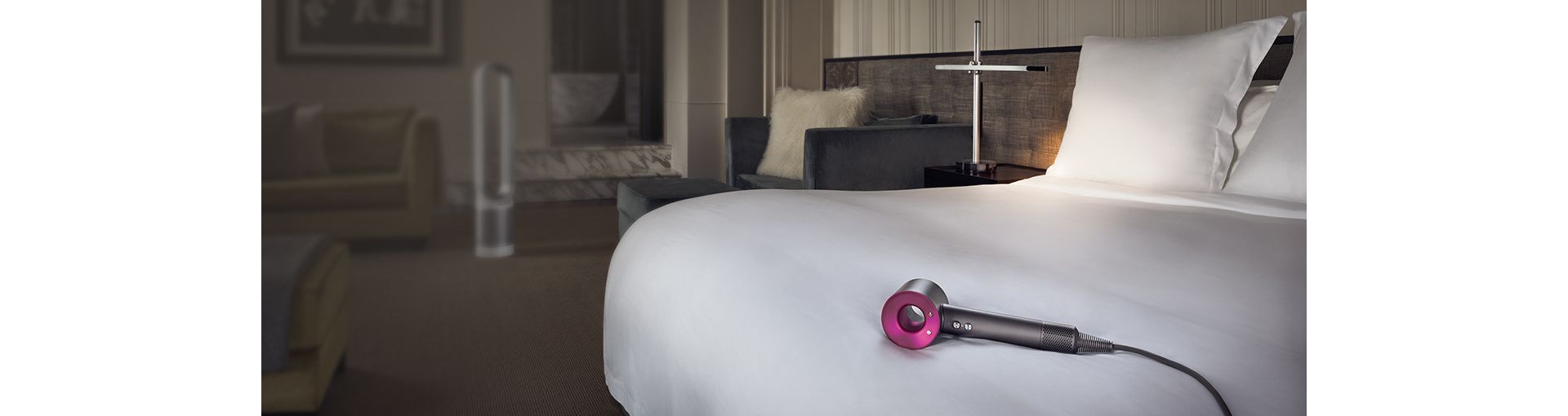 Immagini di Dyson Supersonic sul letto di una camera d'hotel