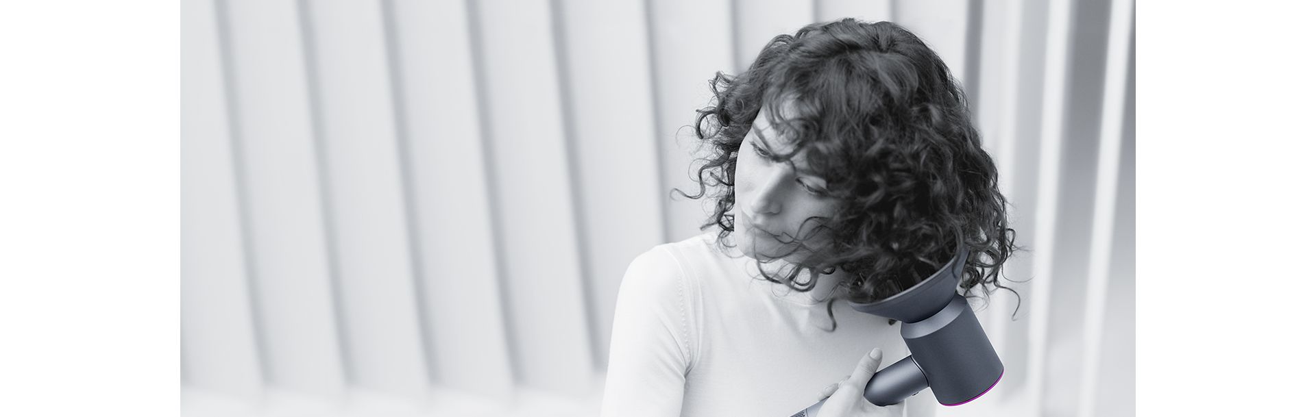 Una donna si asciuga i capelli con l’asciugacapelli Dyson Supersonic