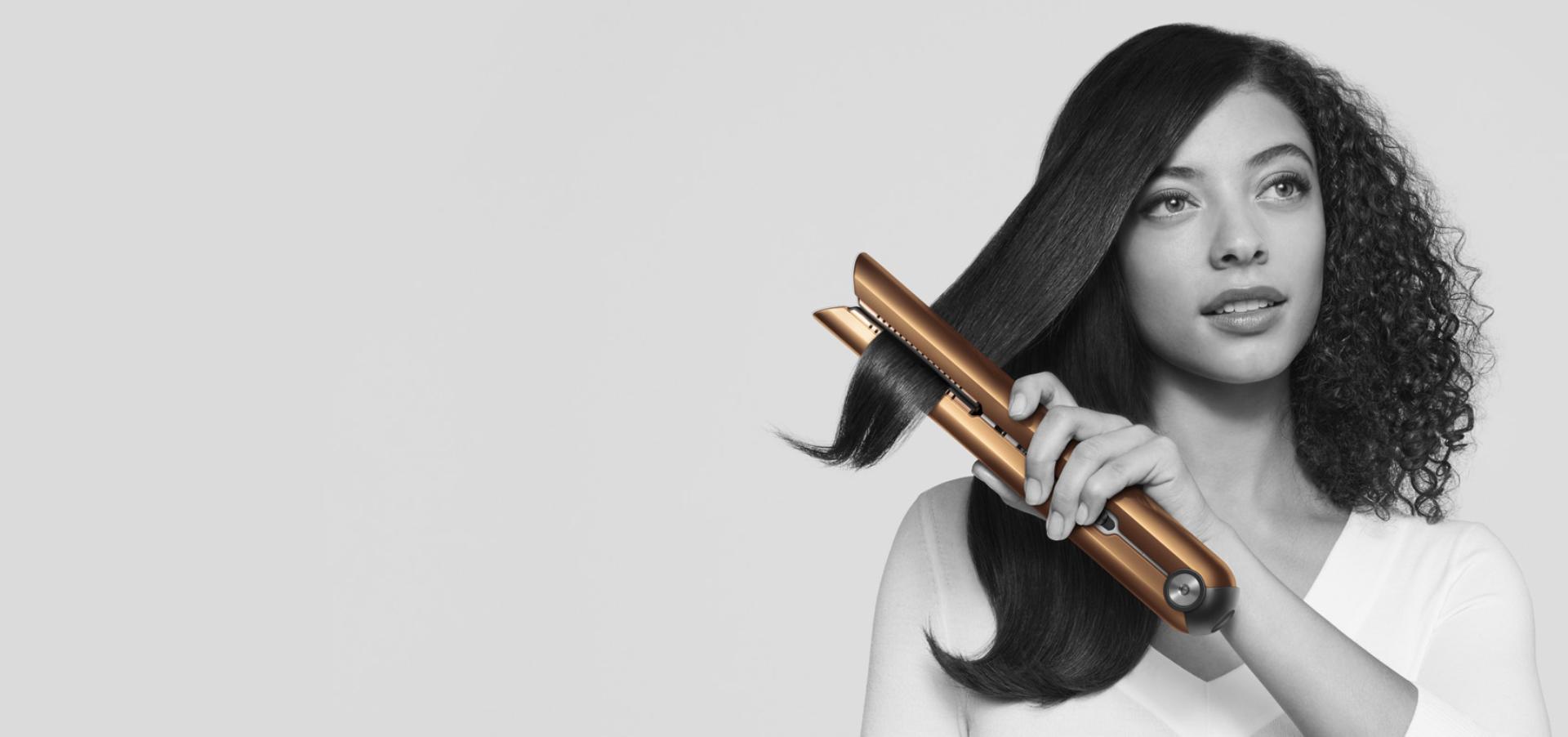 Kadın Dyson Corrale™ saç düzleştiriciyi kullanıyor