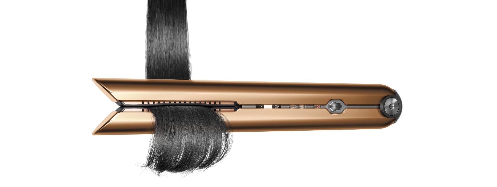 Dyson Corrale saç düzleştirici saçı aşağı doğru çekerek şekillendiriyor.