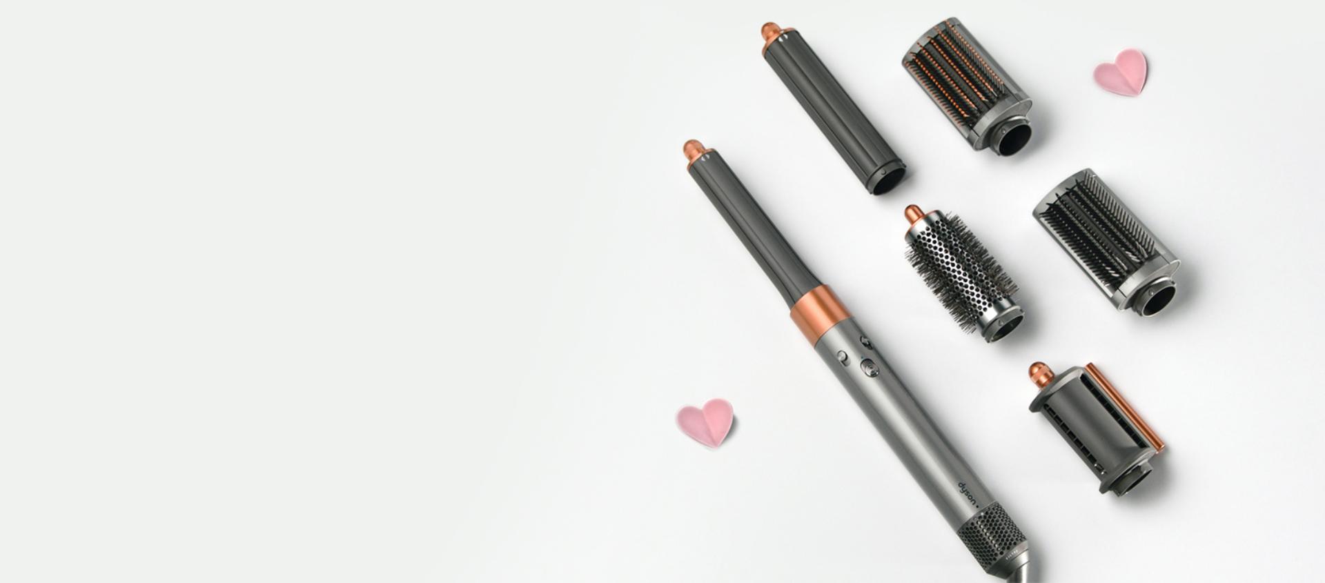 The Dyson Supersonic r hair dryer hanging in a line between a pair of Christmas stockings.