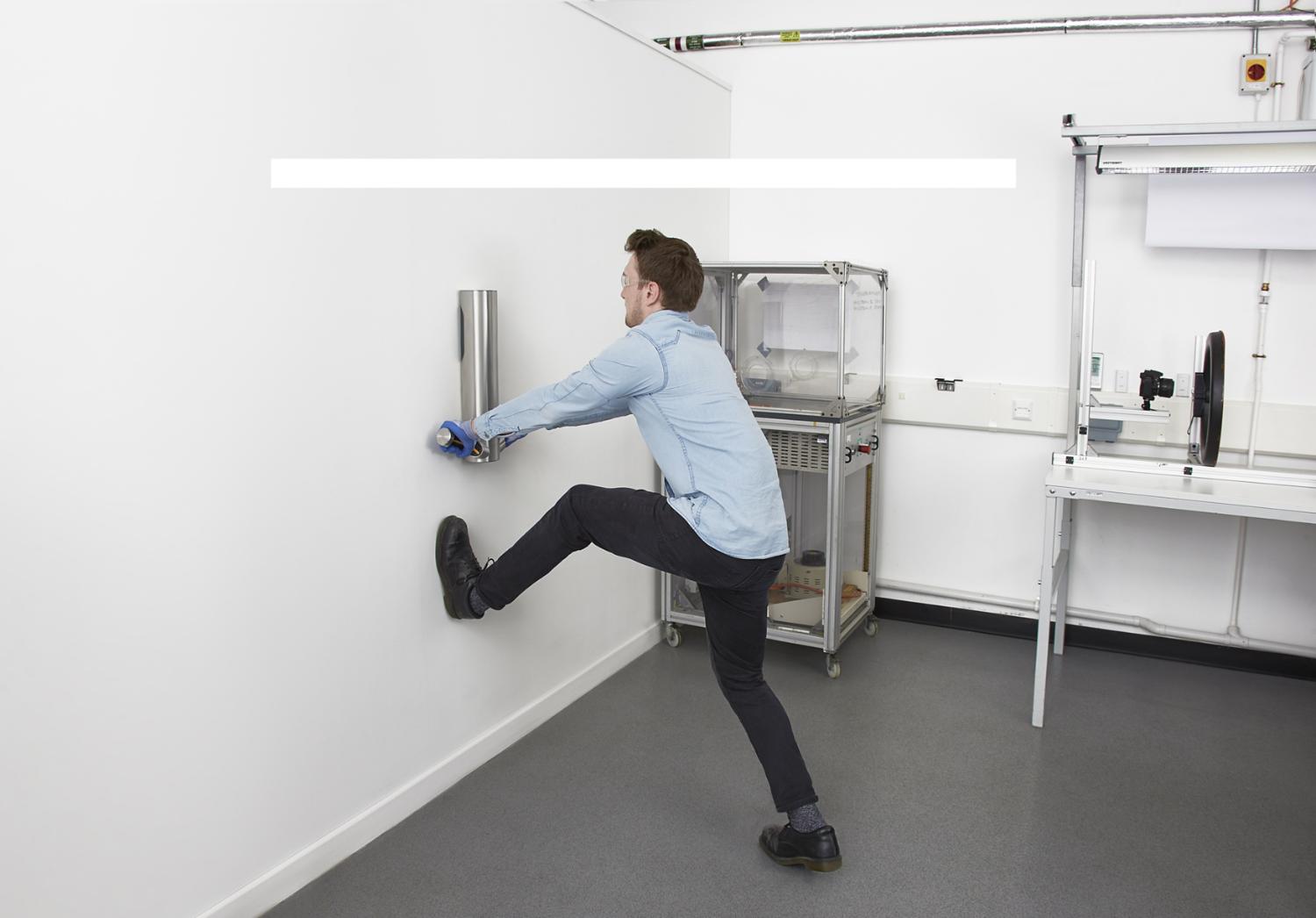 Engineer testing robustness of Dyson Airblade 9kJ hand dryer
