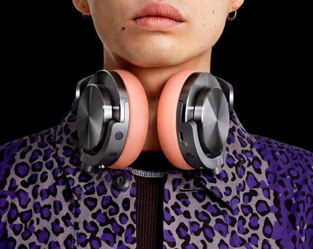 Model with the Dyson Ontrac headphones round their neck, with CNC aluminium caps and Oyster pink cushions.