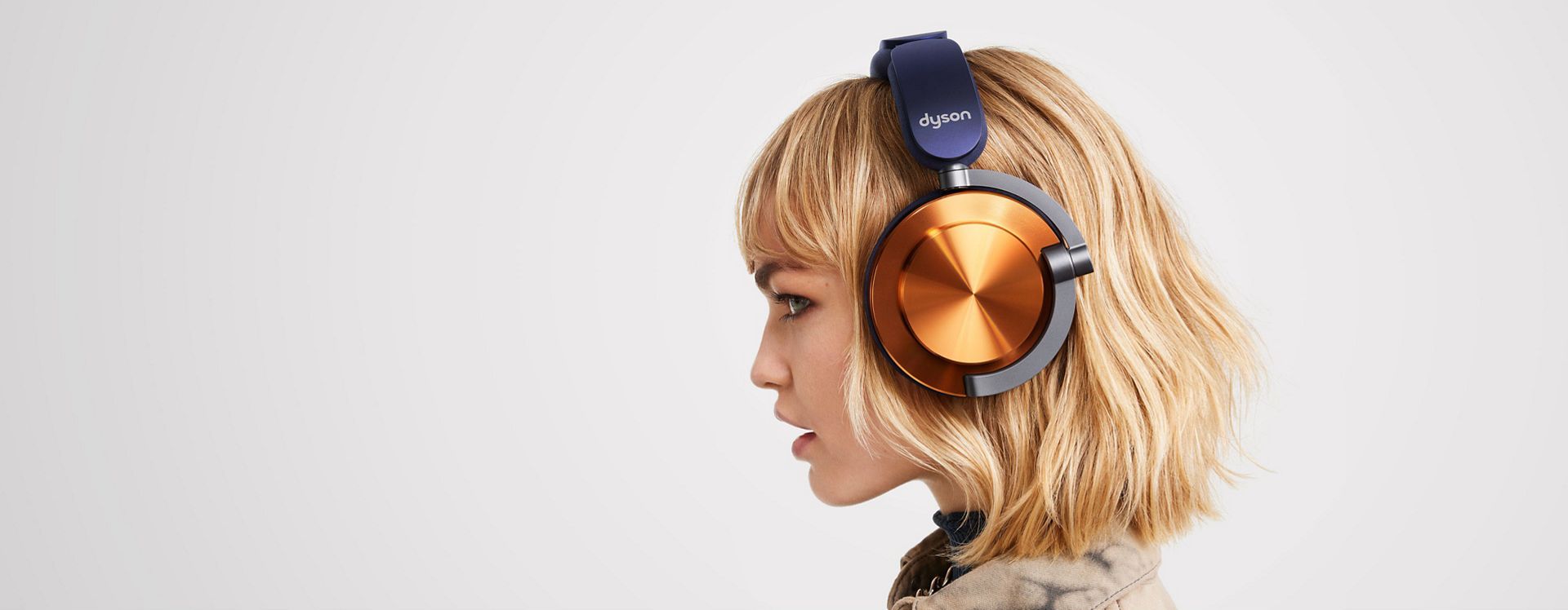 A side profile of a model wearing Dyson OnTrac headphones with CNC copper outer caps.