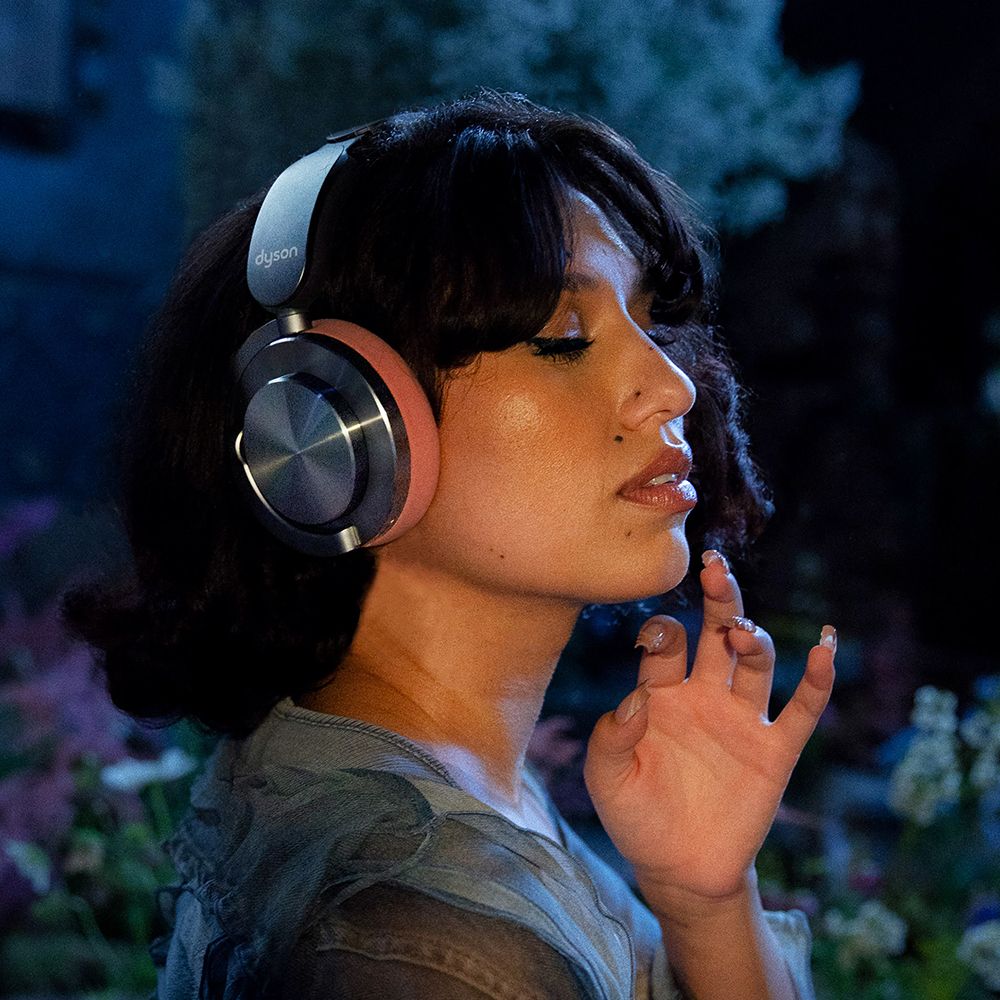 A model wearing Dyson OnTrac headphones with CNC copper outer caps.