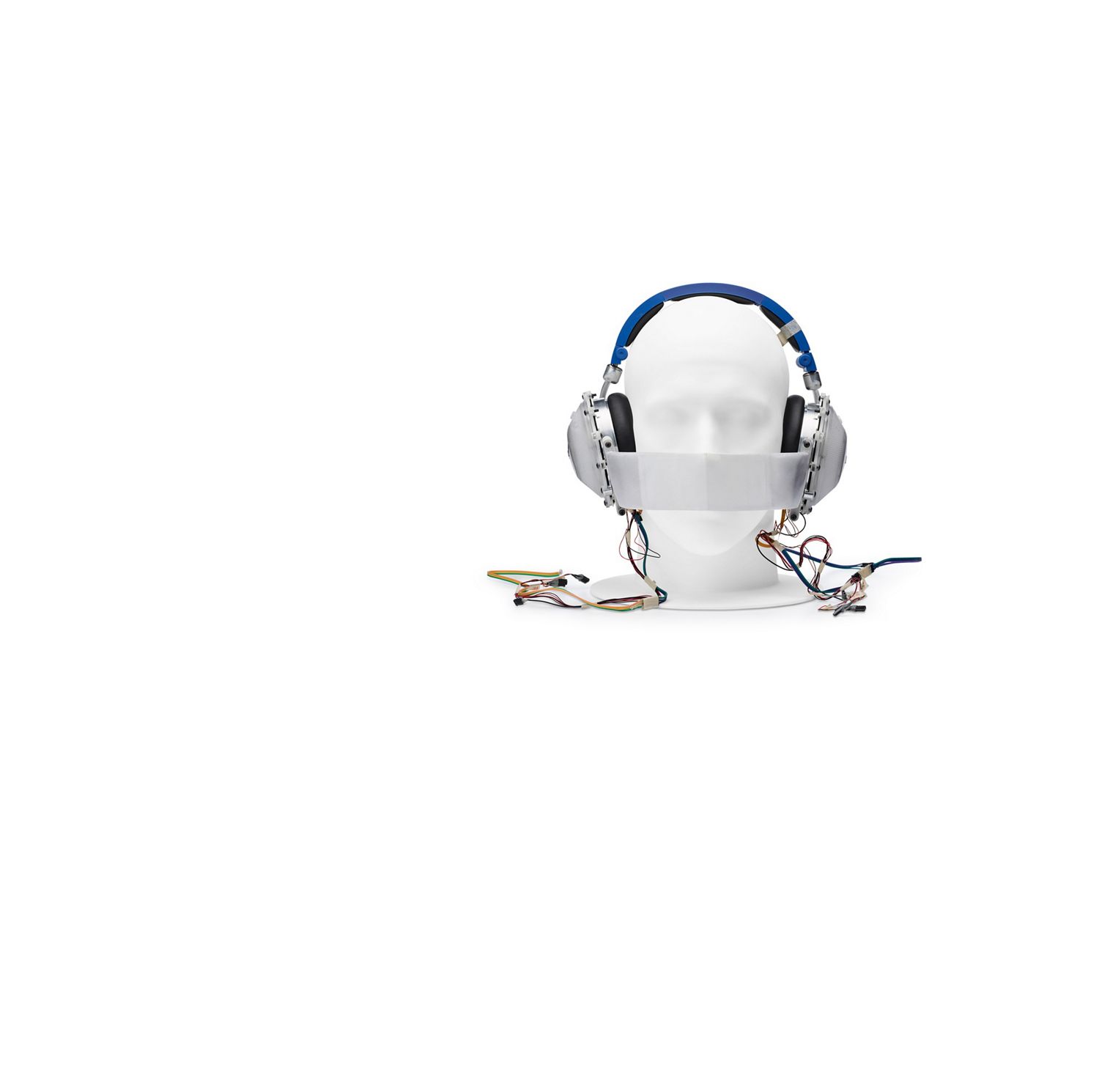 Mannequin  head wearing prototype headphones, with band across nose and mouth, and wires coming from the earcups