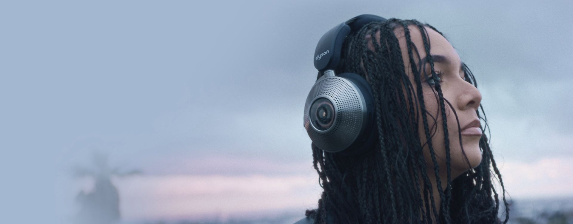 Woman wearing  Dyson Zone noise-cancelling headphones in an outdoor setting.