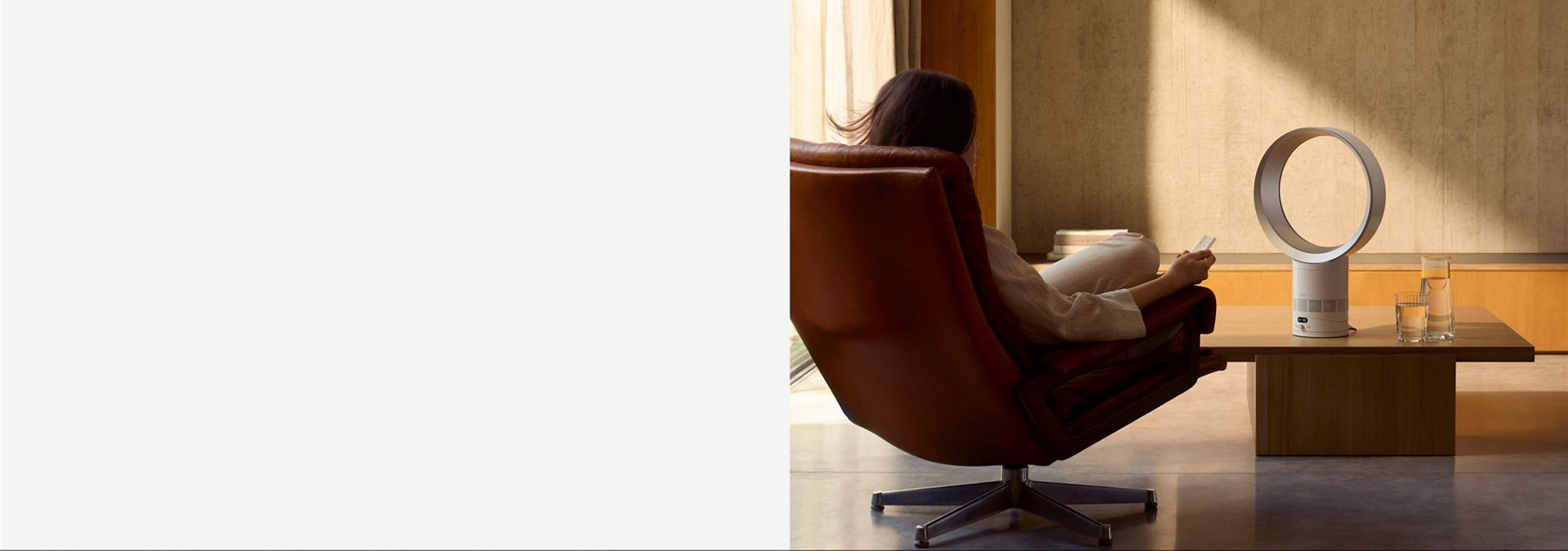 The Dyson Cool CF1 delivering a cool breeze to a person relaxing in a chair.