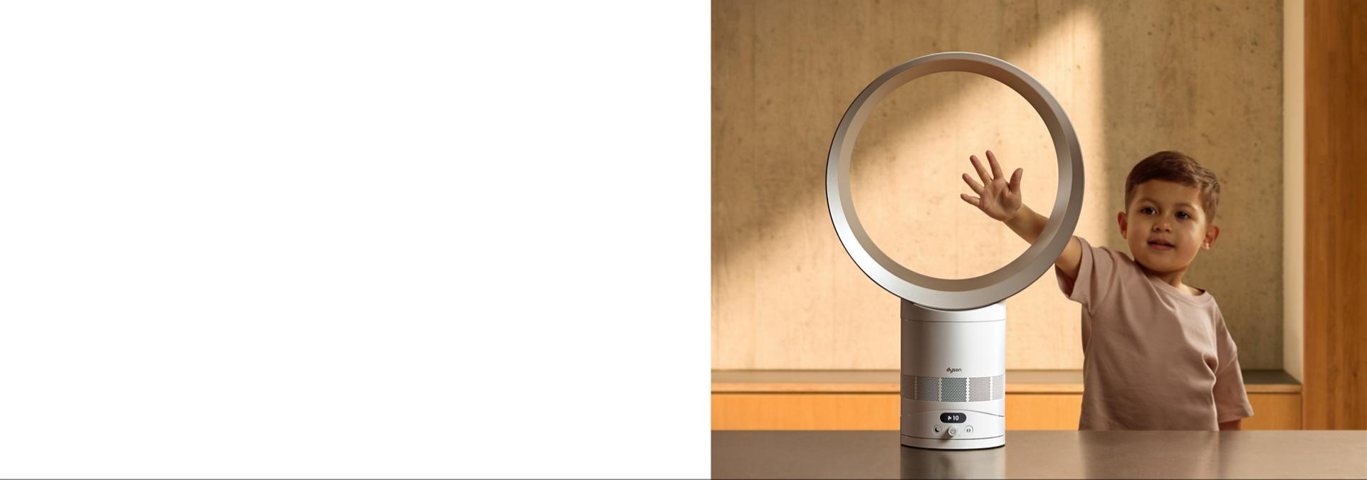 A child putting their hand in the loop of the Dyson Cool CF1 fan.