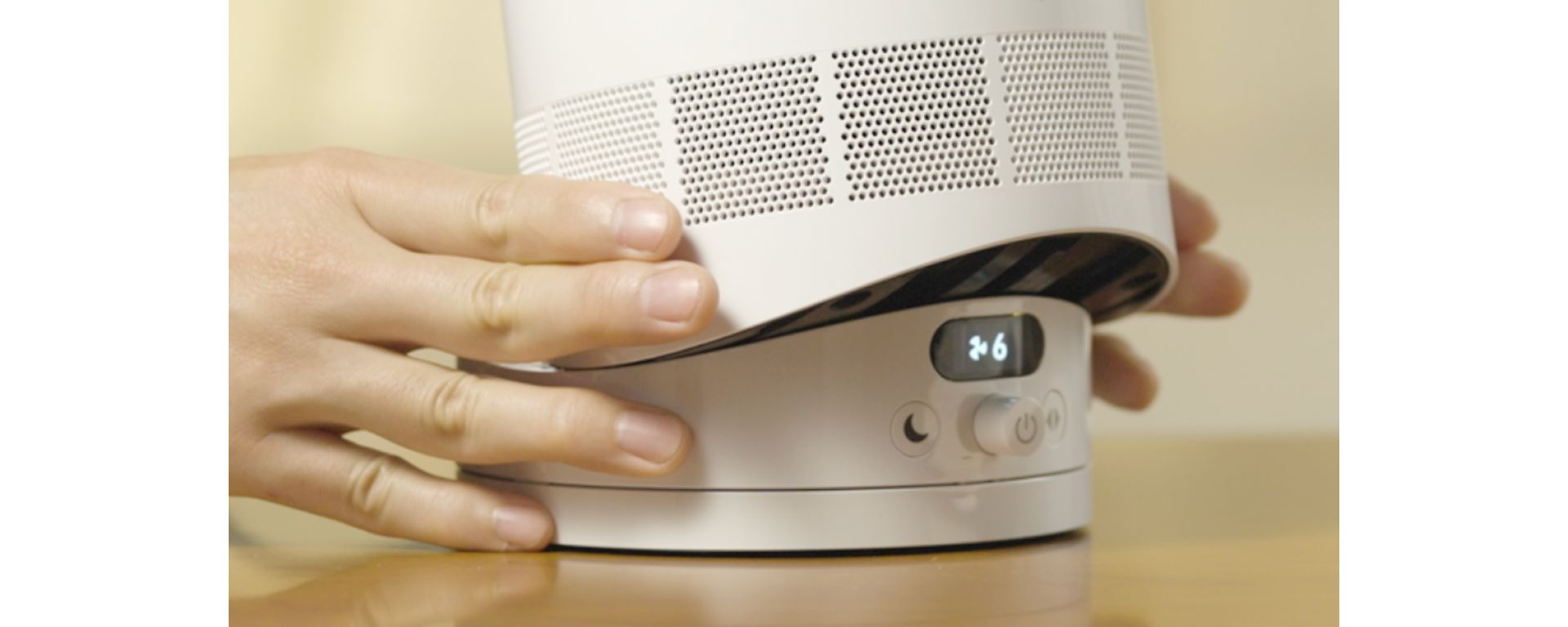 A person tilts the Dyson Cool CF1 fan on its base to direct the airflow.