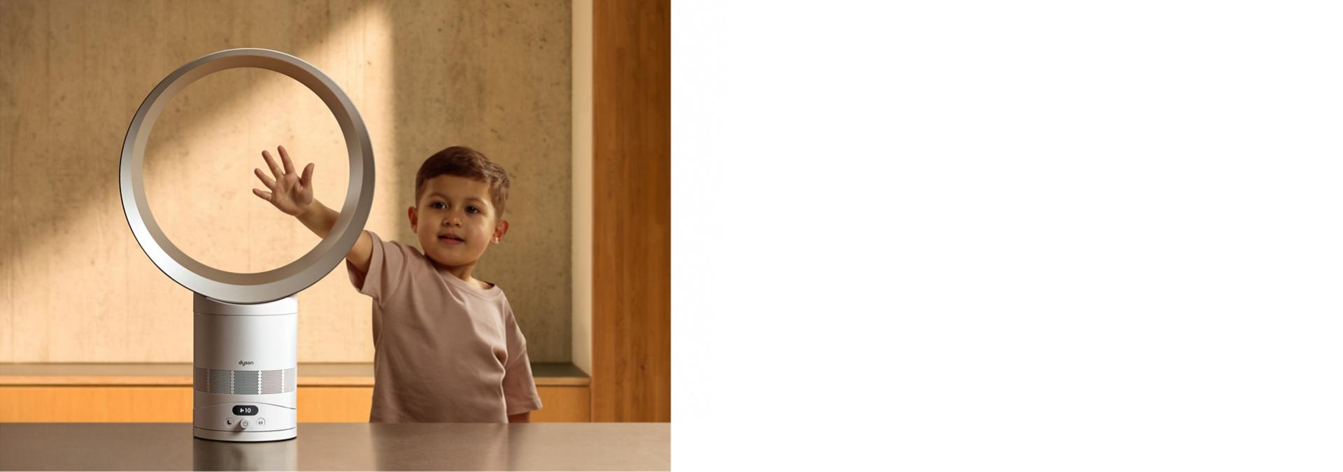 A child putting their hand in the loop of the Dyson Cool CF1 fan.
