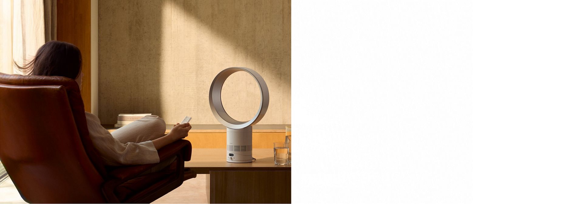 Der Dyson Cool CF1 liefert einer Person, die in einem Sessel entspannt, eine kühle Brise.