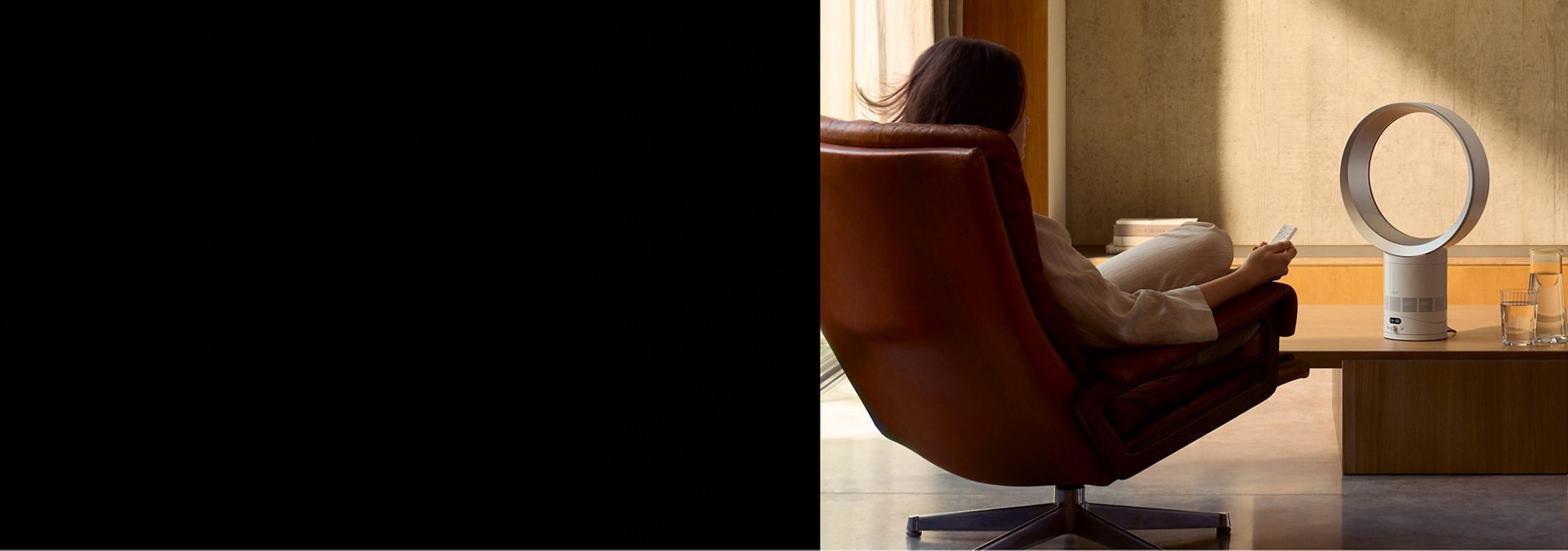 The Dyson Cool CF1 delivering a cool breeze to a person relaxing in a chair.