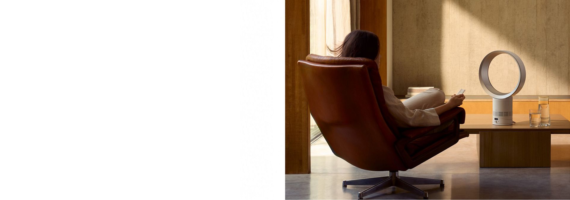 The Dyson Cool CF1 fan delivering a cool breeze to a person relaxing in a chair.