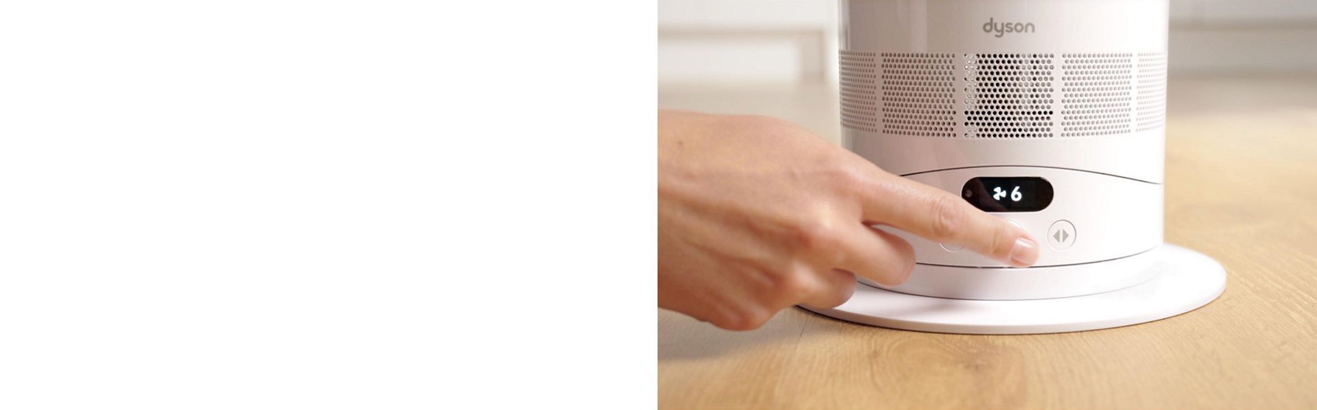 A finger presses the middle dial of the Dyson Hot+Cool HF1 Remote Link Pre-heat heater and cooling fan to turn it on.