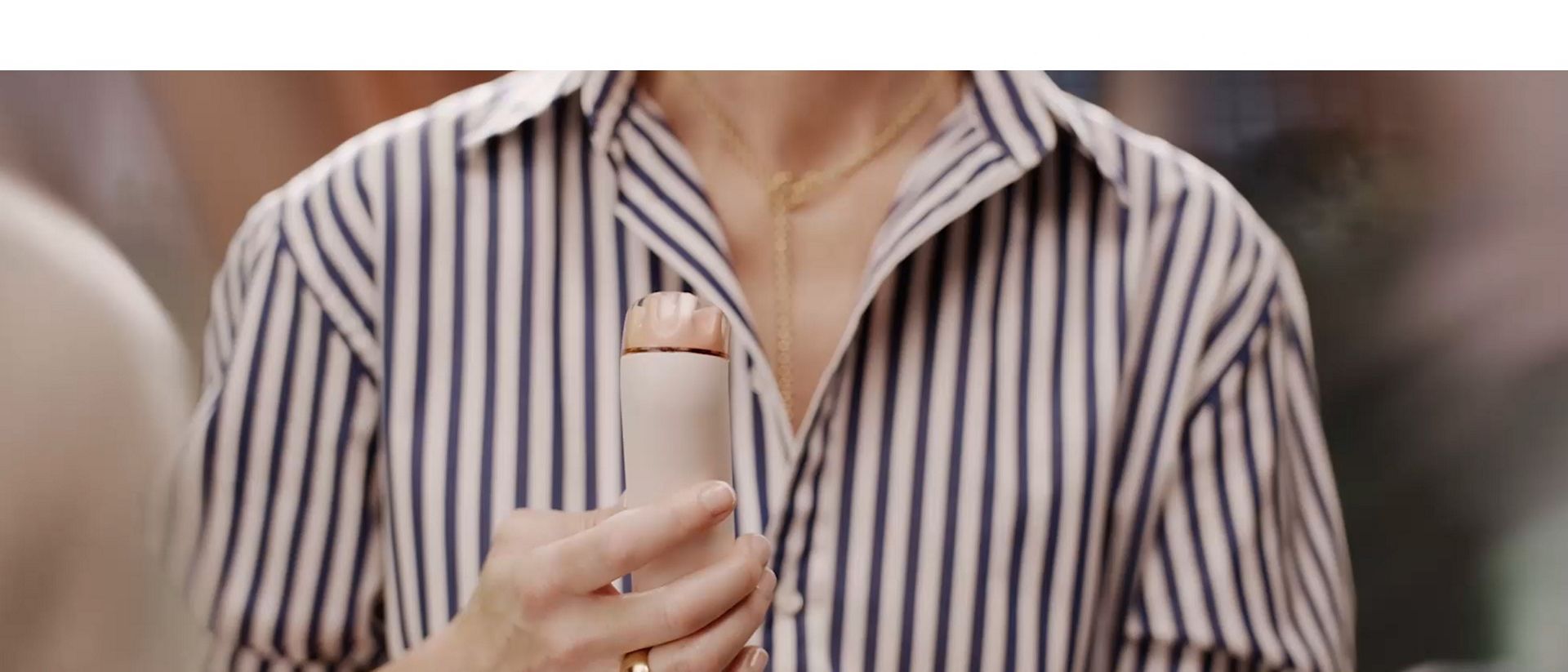 Dyson HushJet Mini Cool portable fan held by a spectator at an event.