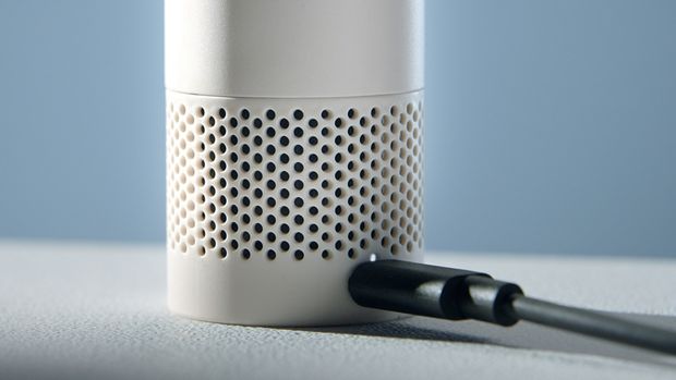 The Dyson HushJet Mini Cool fan charges on a desk.