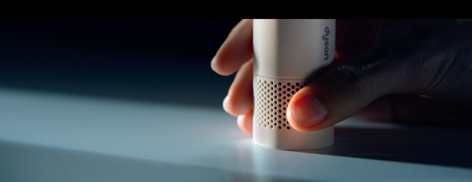 The air inlet of the Dyson HushJet Mini Cool fan is obstructed by a hand.