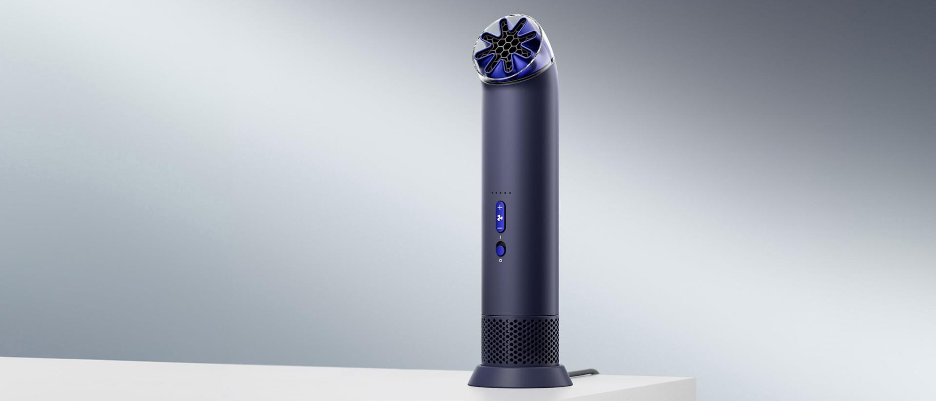 Prenosný ventilátor Dyson HushJet Mini Cool v nabíjacom stojane na stole.