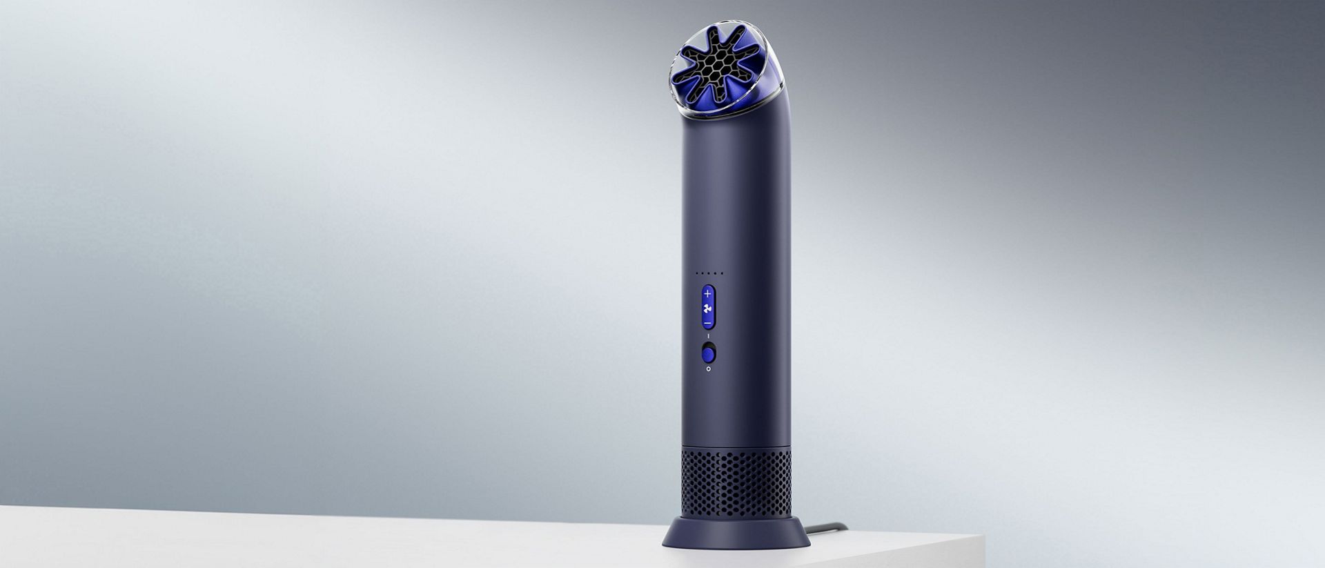 Prenosný ventilátor Dyson HushJet Mini Cool v nabíjacom stojane na stole.
