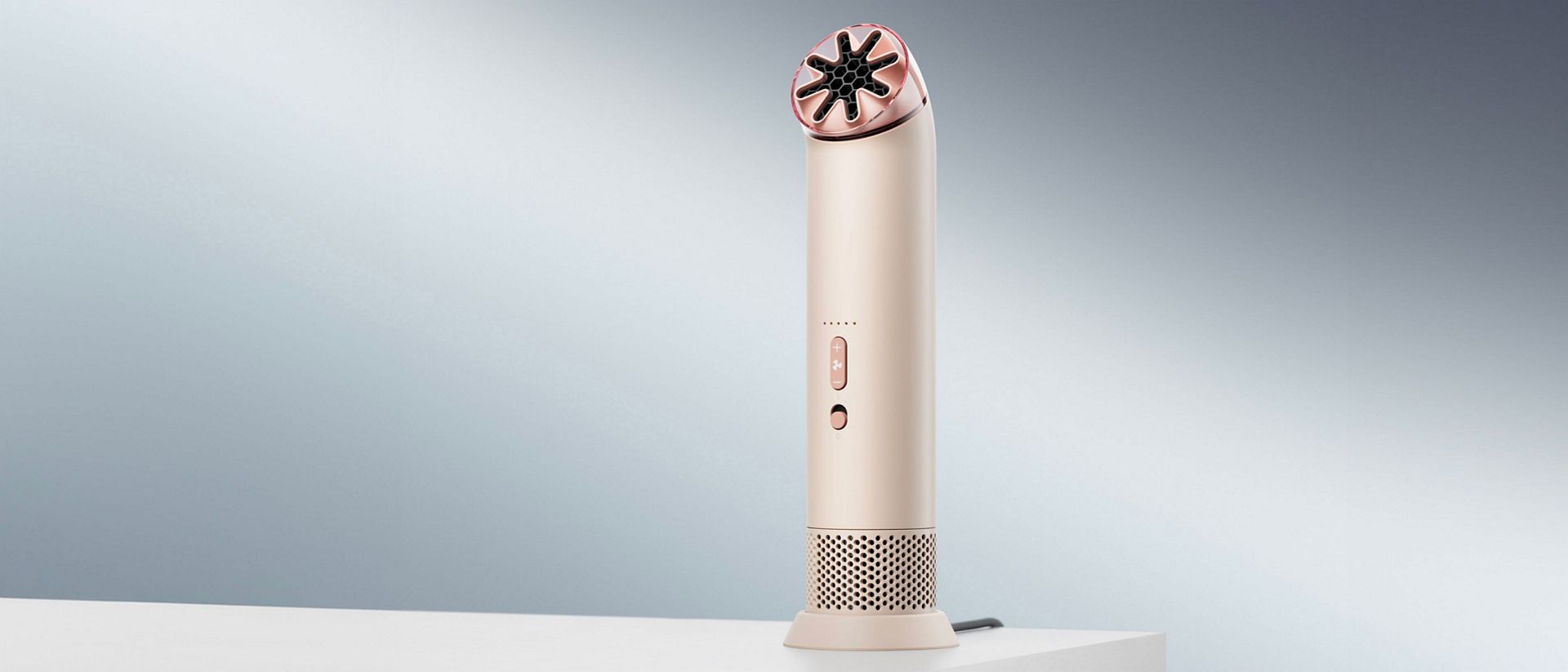 Prijenosni ventilator Dyson HushJet Mini Cool na stalku za punjenje na stolu.