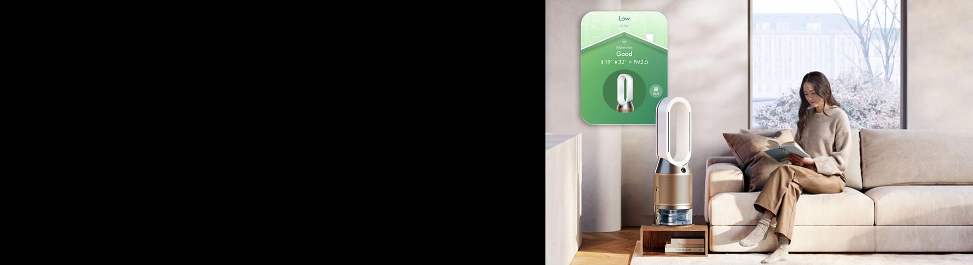 Dyson Purifier Humidify+Cool PH2 De-NOx with app controls next to a woman reading a book.