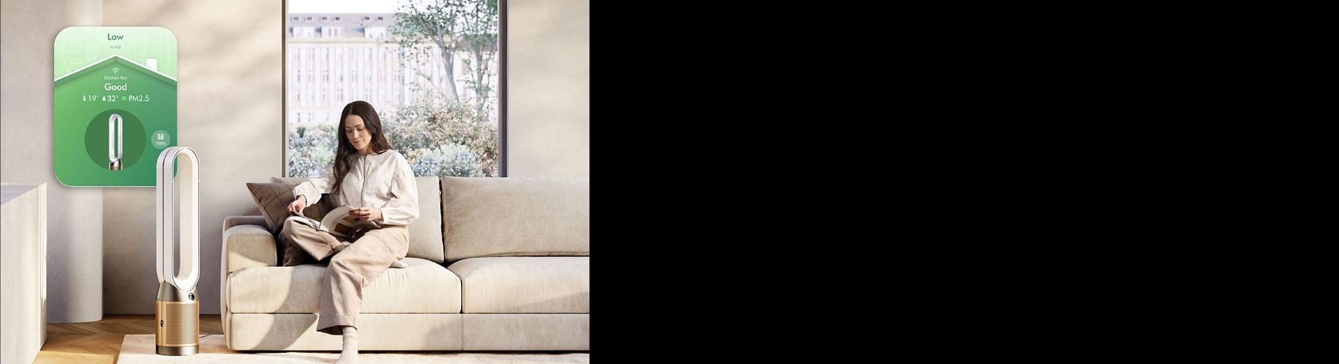 جهاز Dyson Purifier Cool PC2 De-NOx مع عناصر تحكم التطبيق بجوار امرأة تقرأ كتابًا.