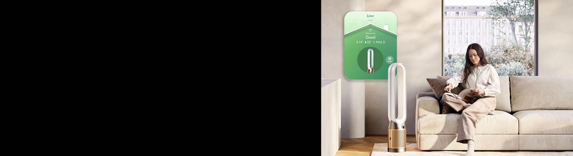 Dyson Purifier Cool PC2 De-NOx with app controls next to a woman reading a book.