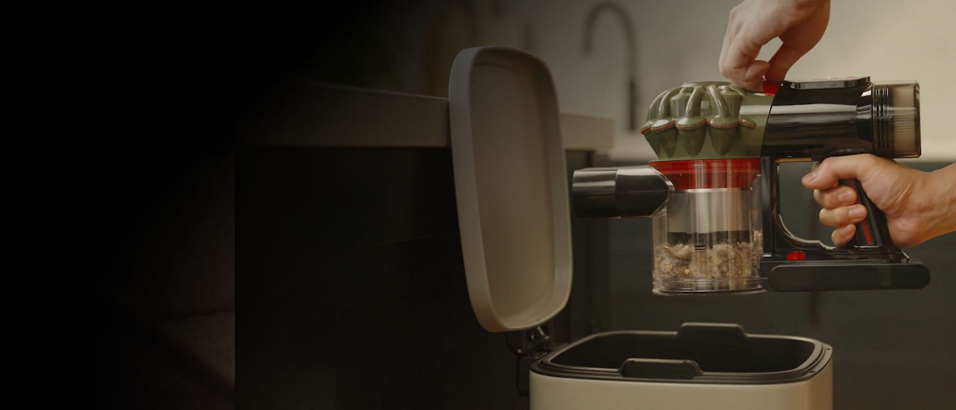 The Dyson V8 Cyclone cordless vacuum is emptied into a household bin.