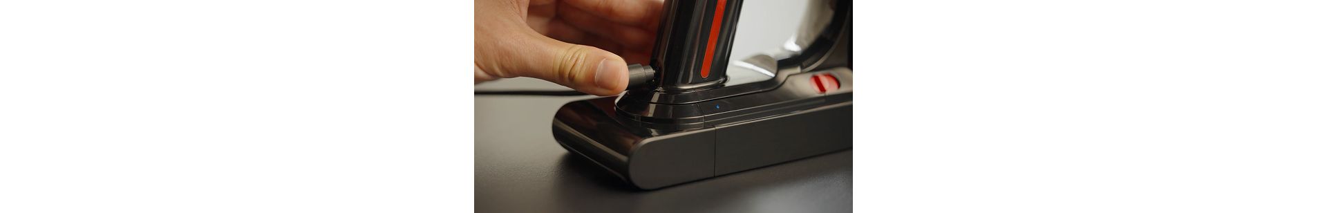 The battery of the Dyson V8 Cyclone vacuum is plugged into charge.