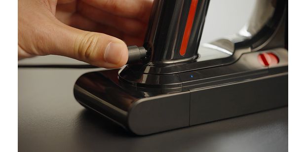 بطارية مكنسة دايسون V8 Cyclone موصولة بالشاحن.