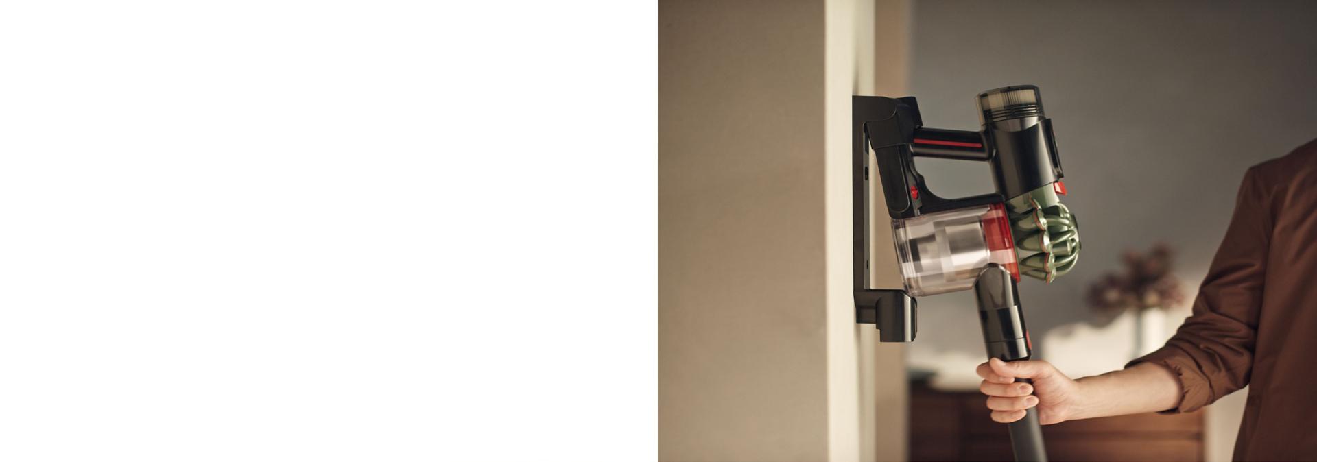 The Dyson V8 Cyclone vacuum is returned to its charging dock.